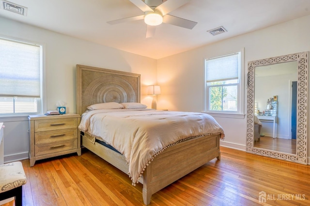 bedroom with light wood-type flooring, multiple windows, ceiling fan, and baseboards