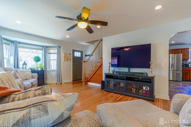 living area featuring ceiling fan, stairs, baseboards, and recessed lighting