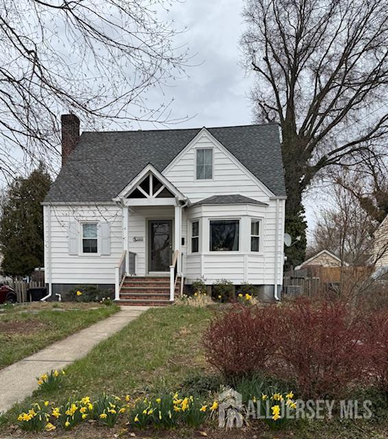 bungalow-style house featuring a chimney and roof with shingles