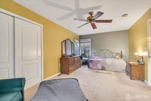 bedroom featuring ceiling fan, a closet, and light carpet