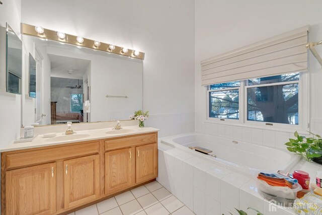 bathroom featuring vanity, tile patterned flooring, and a relaxing tiled tub