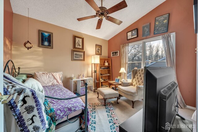 living area with vaulted ceiling, a textured ceiling, ceiling fan, and carpet flooring