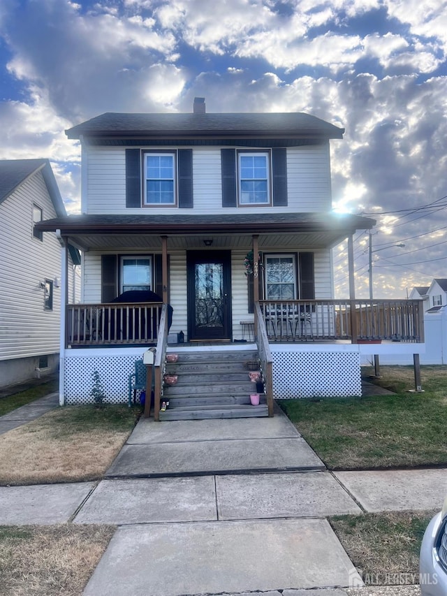 view of front of house with a porch and a front yard