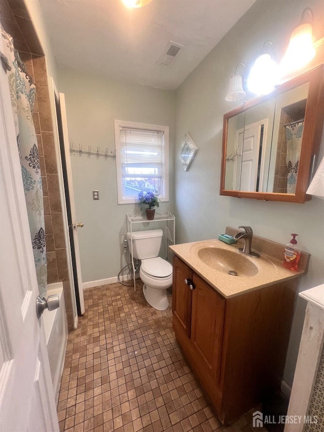 bathroom featuring tile patterned flooring, vanity, and toilet