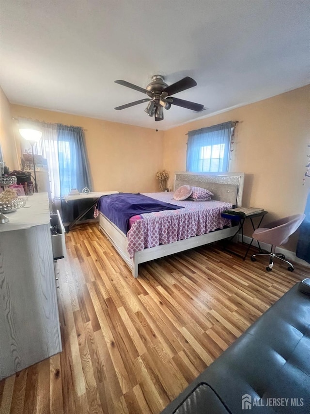 bedroom with ceiling fan and light hardwood / wood-style floors