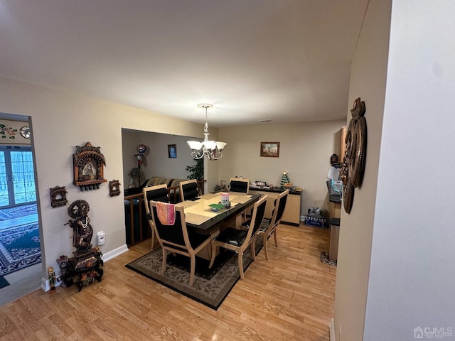 dining area featuring a notable chandelier and light hardwood / wood-style flooring