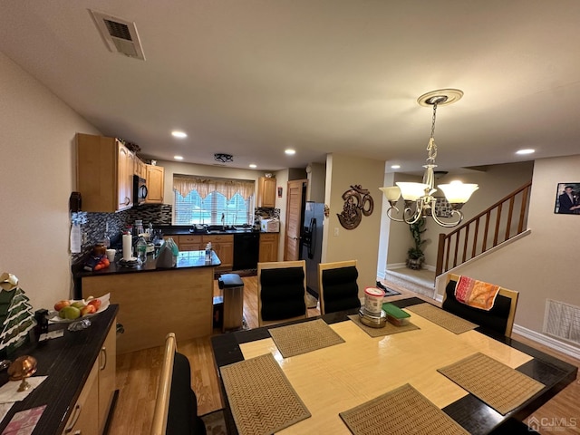 dining room featuring sink, a chandelier, and hardwood / wood-style flooring