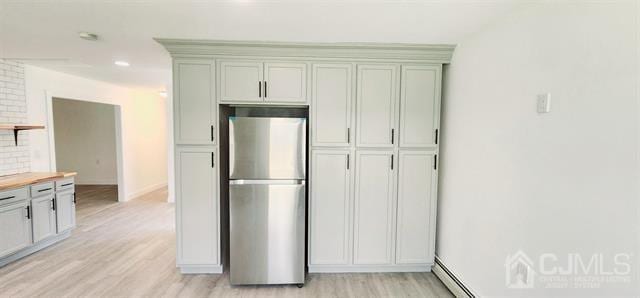 kitchen featuring butcher block countertops, stainless steel refrigerator, a baseboard radiator, and light hardwood / wood-style floors