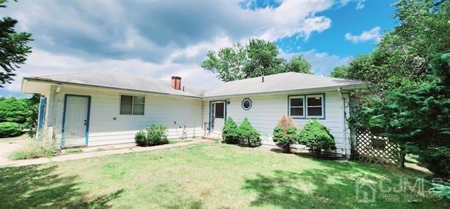 rear view of property featuring a lawn