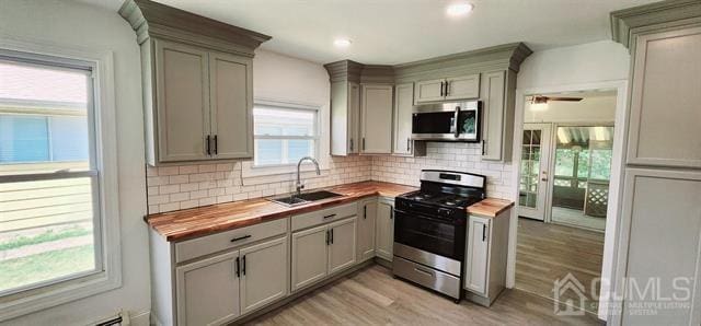 kitchen featuring butcher block countertops, a wealth of natural light, appliances with stainless steel finishes, and sink