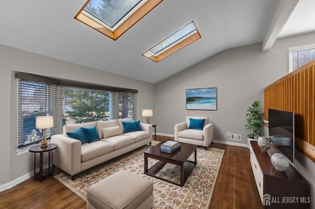 living area featuring baseboards, vaulted ceiling with skylight, and wood finished floors