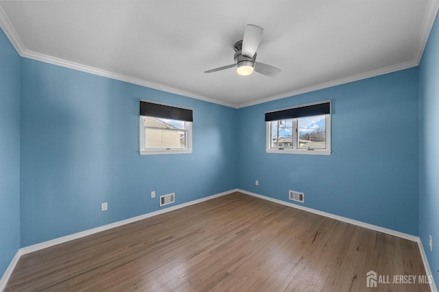 unfurnished room featuring visible vents, plenty of natural light, and wood finished floors