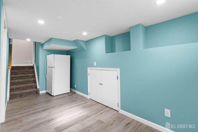 empty room with visible vents, baseboards, light wood-type flooring, stairs, and recessed lighting