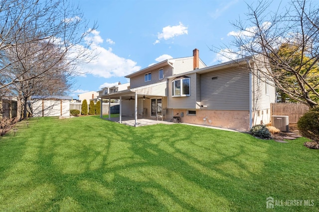 back of house featuring a fenced backyard, ceiling fan, a chimney, and a patio area