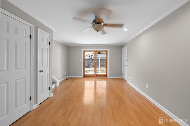 empty room with light wood-style floors, a ceiling fan, crown molding, and baseboards