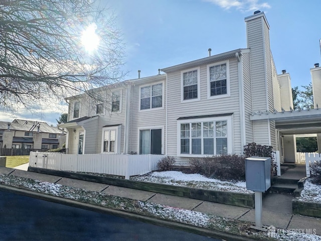 view of front of home with a fenced front yard and a chimney