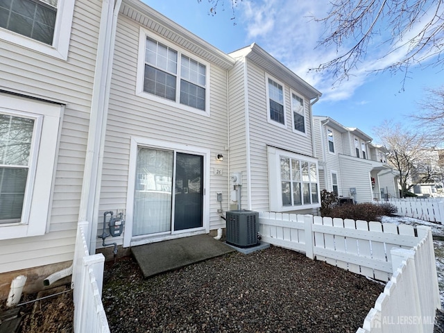 back of property with fence and central air condition unit