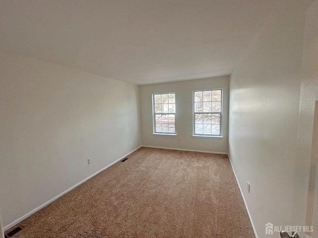 carpeted empty room with baseboards and visible vents