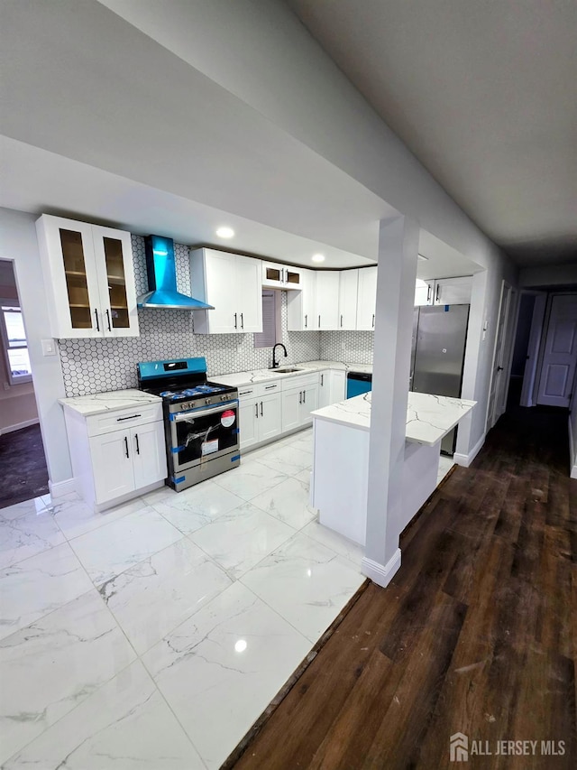 81 Hickory St, Carteret, NJ 07008 - kitchen featuring stainless steel gas range, wall chimney exhaust hood, light stone counters, glass insert cabinets, and white cabinets