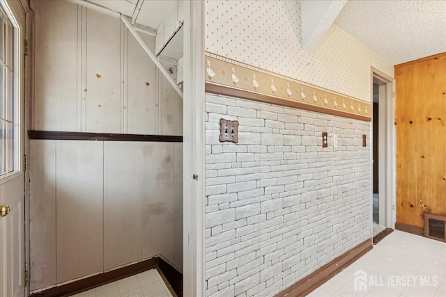 78 Bernard St, Carteret, NJ 07008 - bathroom with brick wall, tile patterned floors, and a textured ceiling