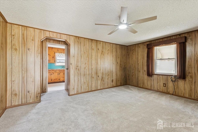 78 Bernard St, Carteret, NJ 07008 - carpeted empty room featuring a textured ceiling, ceiling fan, and wood walls
