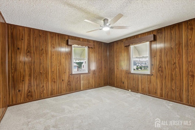 78 Bernard St, Carteret, NJ 07008 - unfurnished room with ceiling fan, healthy amount of natural light, a textured ceiling, carpet, and wood walls