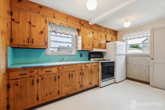 78 Bernard St, Carteret, NJ 07008 - kitchen with gas range oven, brown cabinetry, a textured ceiling, light countertops, and freestanding refrigerator