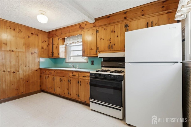 78 Bernard St, Carteret, NJ 07008 - kitchen featuring freestanding refrigerator, gas stove, light countertops, brown cabinets, and wooden walls