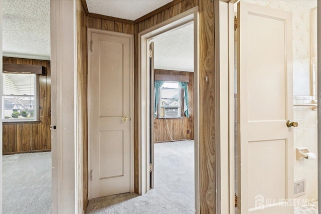 78 Bernard St, Carteret, NJ 07008 - hallway featuring light carpet, wood walls, healthy amount of natural light, and a textured ceiling