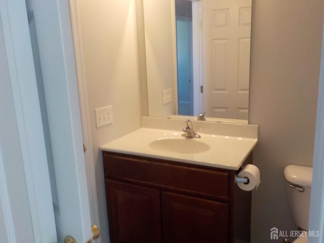 half bath featuring vanity and toilet