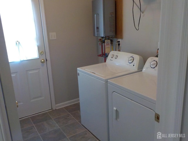 laundry room with washer and clothes dryer, tankless water heater, and baseboards