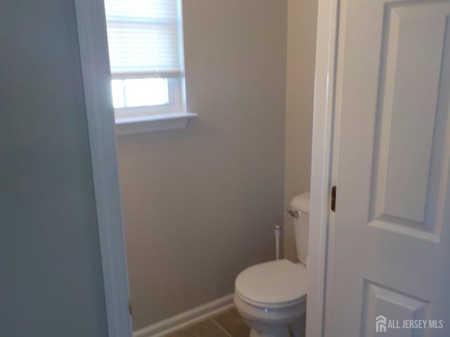 bathroom featuring toilet, baseboards, and tile patterned floors