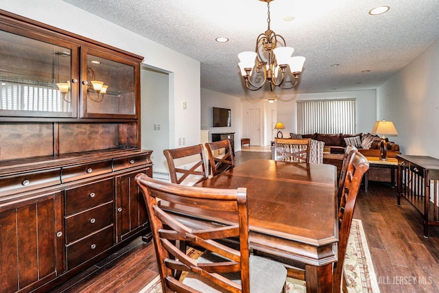 dining room featuring dark wood finished floors, a notable chandelier, a textured ceiling, and recessed lighting