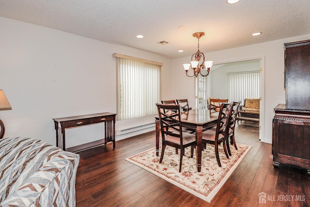 dining room featuring dark wood-style flooring, an inviting chandelier, a textured ceiling, a baseboard heating unit, and recessed lighting