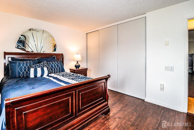 bedroom with a closet, a textured ceiling, and wood finished floors