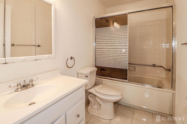 full bath featuring tile patterned flooring, shower / bath combination with glass door, vanity, and toilet