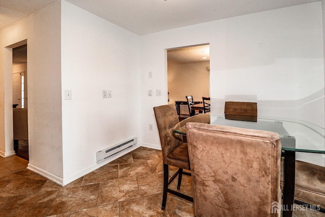 dining area featuring a baseboard heating unit and baseboards