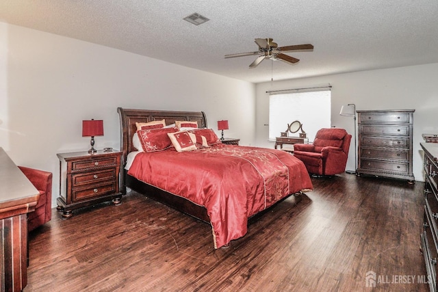 bedroom with a textured ceiling, ceiling fan, wood finished floors, and visible vents