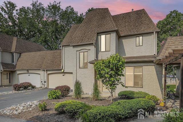 4 Gate House Ln, Edison, NJ 08820 - view of front of home featuring stucco siding, roof with shingles, asphalt driveway, and an attached garage