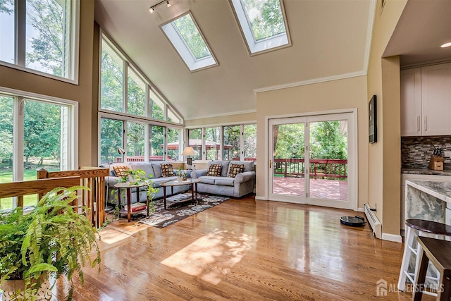 9 NW Fielding Pl, Edison, NJ 08820 - living room with high vaulted ceiling, light wood-style flooring, a skylight, a baseboard heating unit, and crown molding
