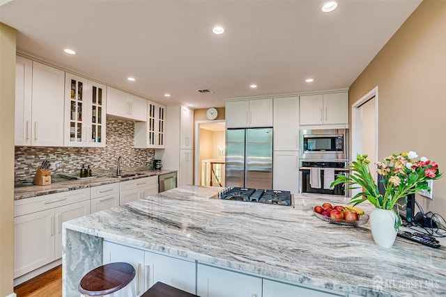 9 NW Fielding Pl, Edison, NJ 08820 - kitchen featuring built in appliances, tasteful backsplash, white cabinets, light stone counters, and recessed lighting