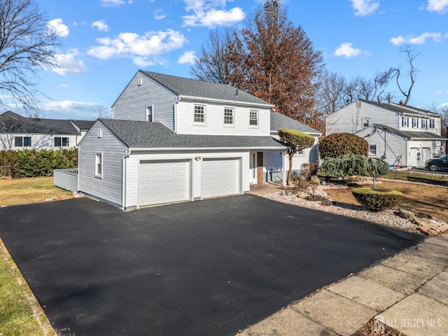 view of front of home featuring aphalt driveway, a shingled roof, and a garage