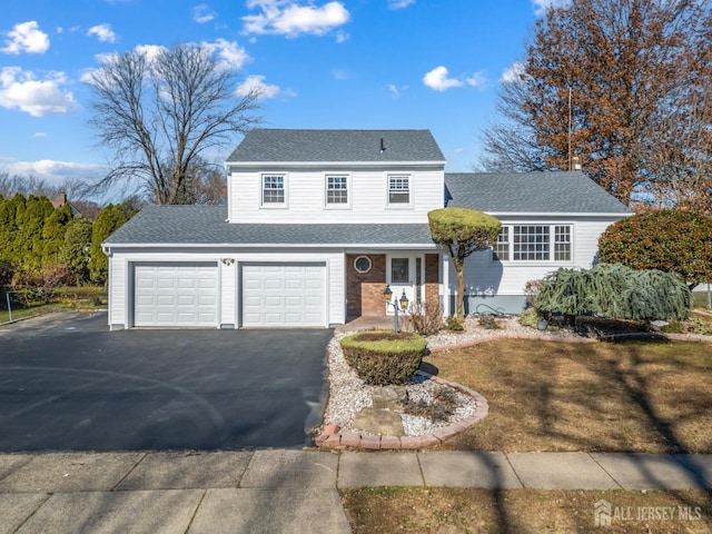 traditional home with a garage, driveway, a shingled roof, and brick siding