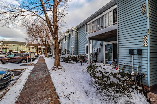 snowy yard featuring a balcony