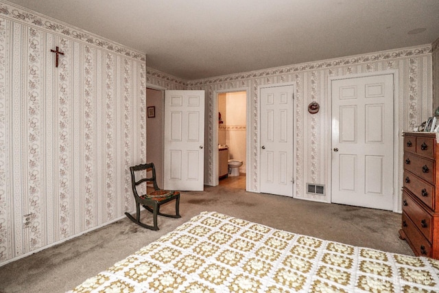 bedroom with carpet flooring and connected bathroom