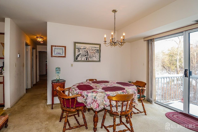 dining space featuring an inviting chandelier and light carpet