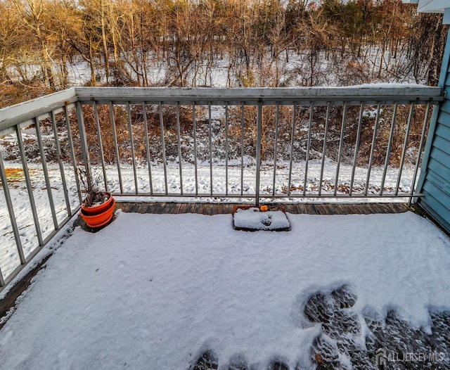 view of snow covered back of property