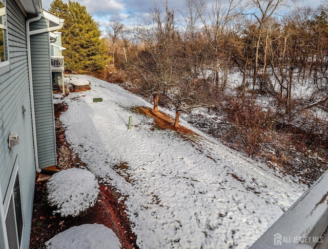 snowy yard featuring a balcony