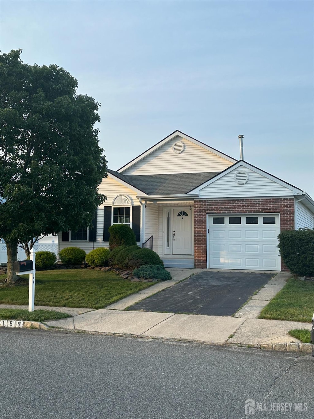 156 Prince Charles Dr, Toms River, NJ 08757 - view of front of home with a garage, asphalt driveway, a front yard, and brick siding