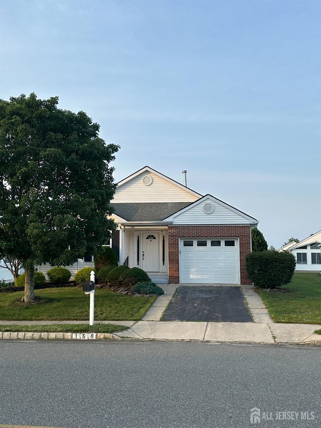 156 Prince Charles Dr, Toms River, NJ 08757 - view of front of home with driveway, an attached garage, a front yard, and brick siding